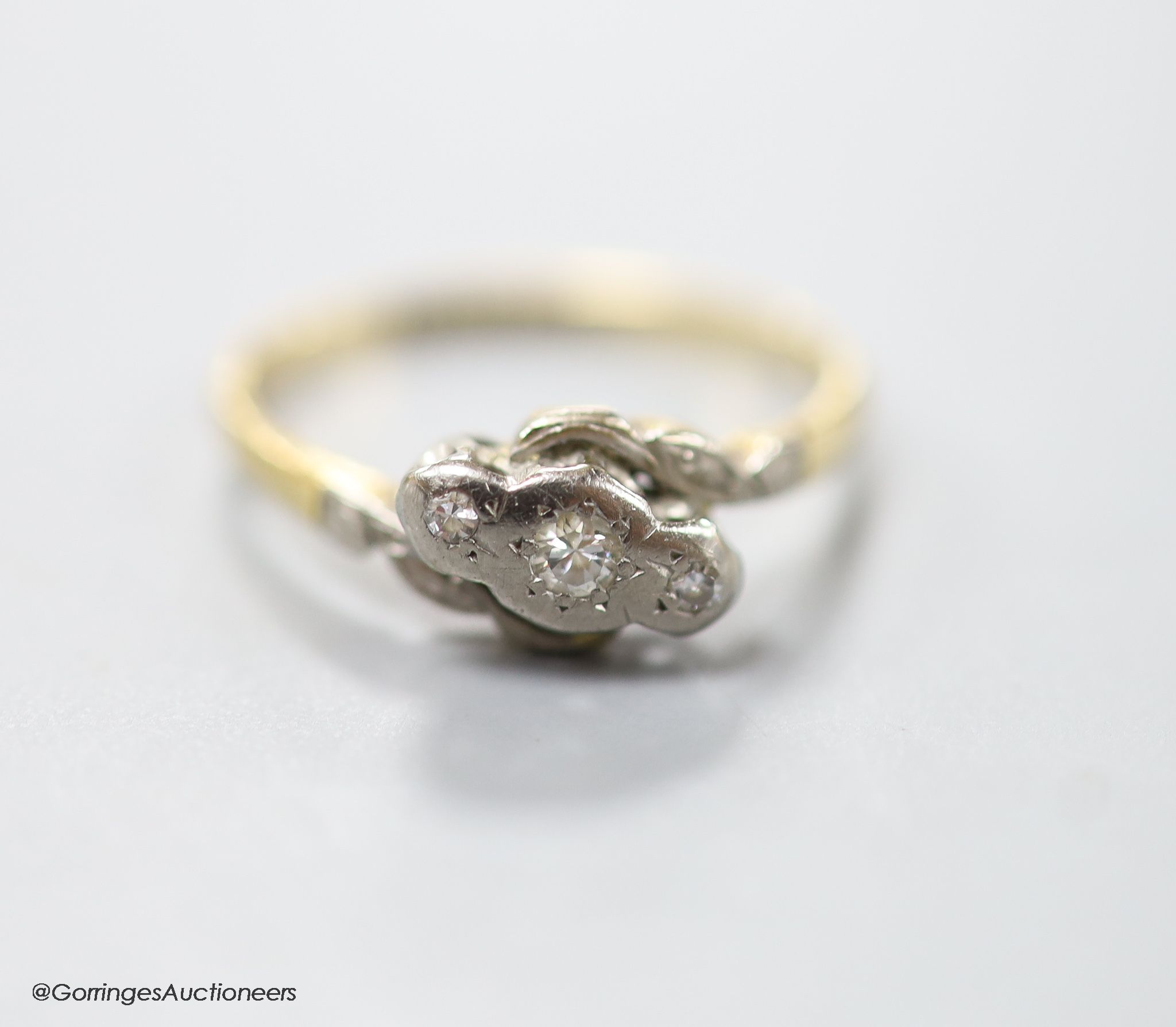 An 18ct & Pt, three stone diamond chip set crossover ring, size M, gross 2.5 grams.